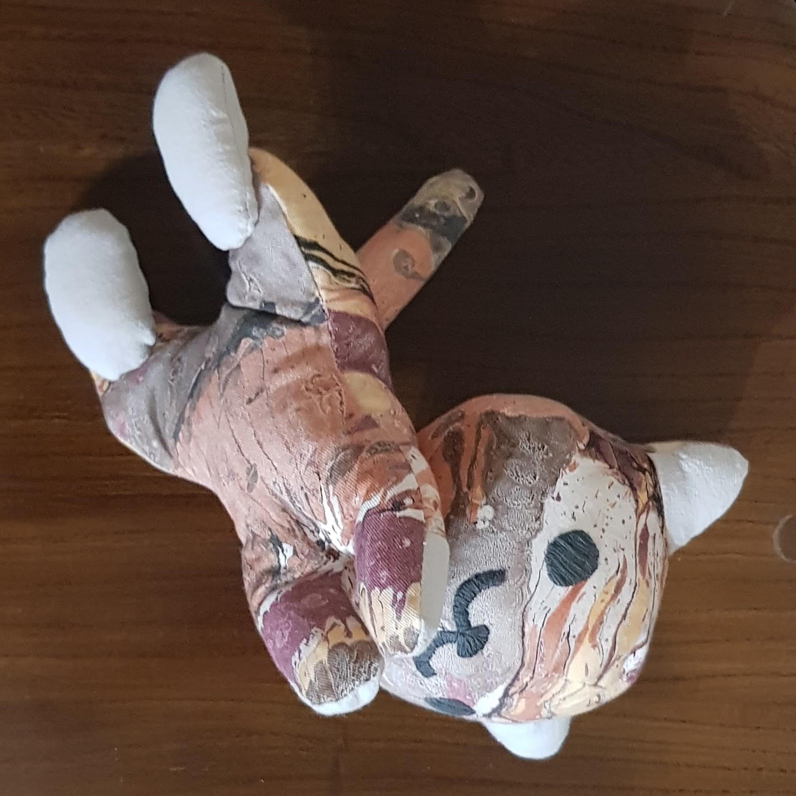Same plush cat as above. This time the stomach is visible as the cat is somewhat on it's back. The cat looks playful.