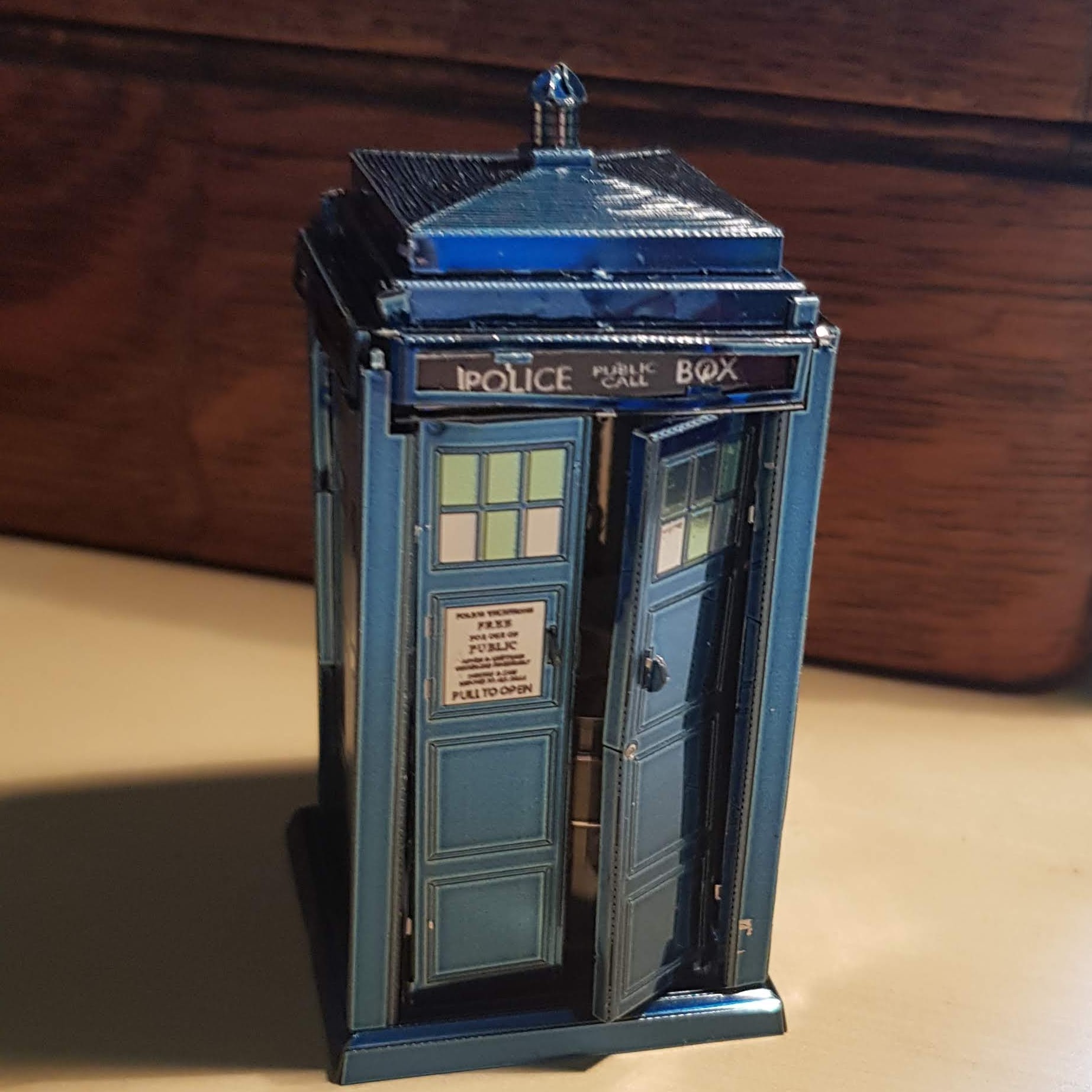 A small aluminium TARDIS. The door to go in is slightly open. It's casting a great shadow.